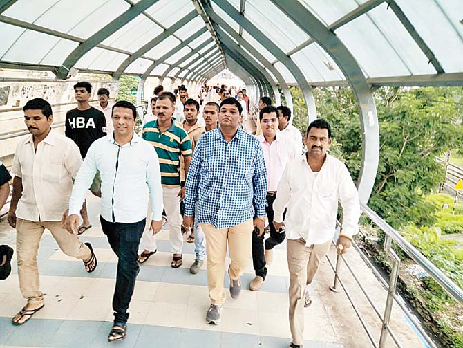 The officials marched up to the skywalk in Badlapur to rid it of hawkers themselves. Pic/Navneet Barhate