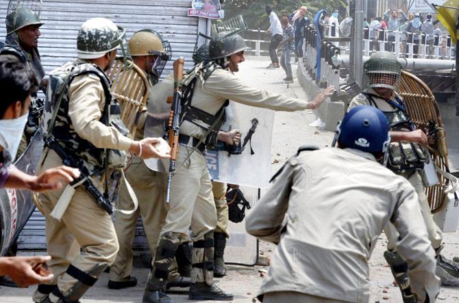 Protesters throw stones at policemen in Srinagar on Saturday. Pic/AFP