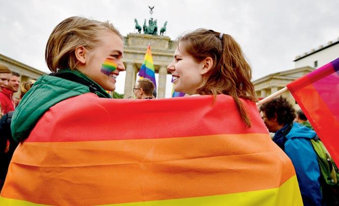 Two women are wrapped in a rainbow flag as they attend a LGBT rally in front of the Brandenburg Gate in Berlin. Pics/AFP
