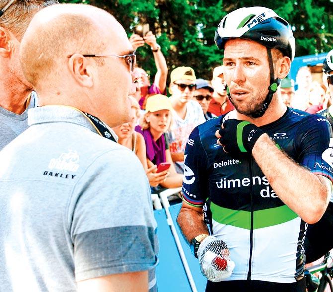 Mark Cavendish talks to an official after the crash during the Tour de France race yesterday