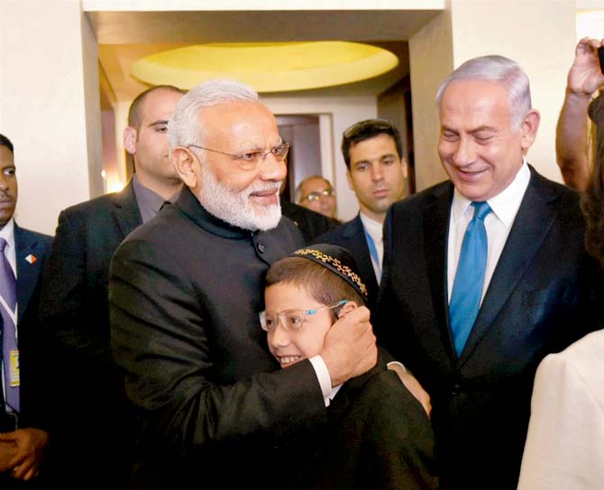 Prime Minister Narendra Modi hugs 11-year-old Moshe Holtzberg, one of the survivors of the 26/11 Mumbai terror attacks, in Jerusalem as Israeli PMâu00c2u0080u00c2u0088Benjamin Netanyahu looks on. Pic/PTI