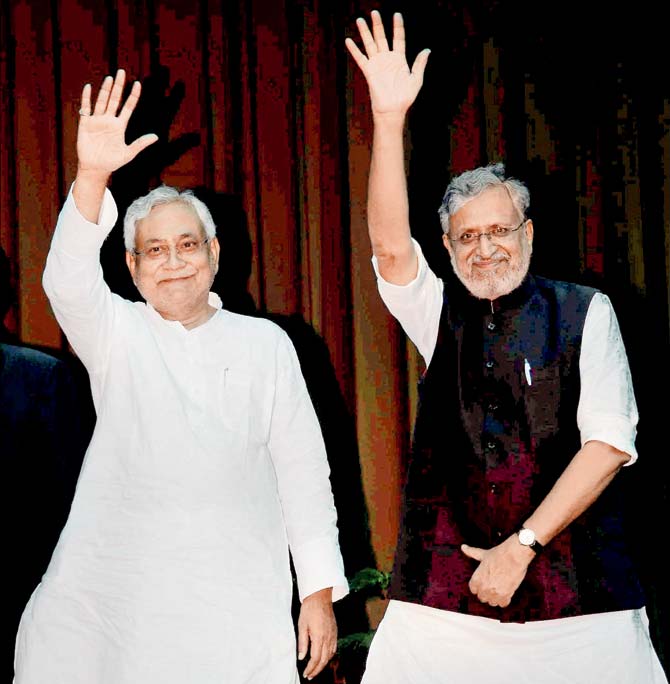 Nitish Kumar and Sushil Kumar Modi wave at a gathering after they were sworn-in as Bihar chief minister and Deputy Chief Minister respectively. Pic/PTI
