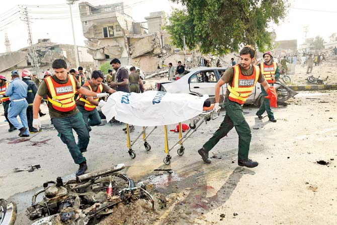 Pakistani rescue workers move the body of a victim at the site of an explosion. Pics/AFP