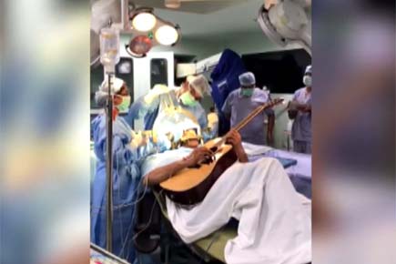 Watch Video: Patient strums guitar as doctors perform brain surgery