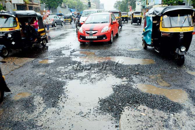 Potholes dot the CD Barfiwala Road in Andheri West. Pic/Satej Shinde