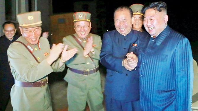 North Korean leader Kim Jong-Un (right) celebrates the test launch of an intercontinental ballistic missile. Pics/AFP