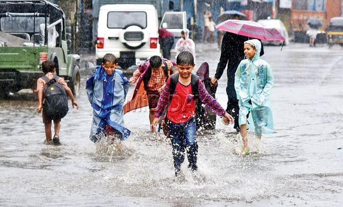 School kids play on a flooded street in Chembur. Pic/Shadab khan