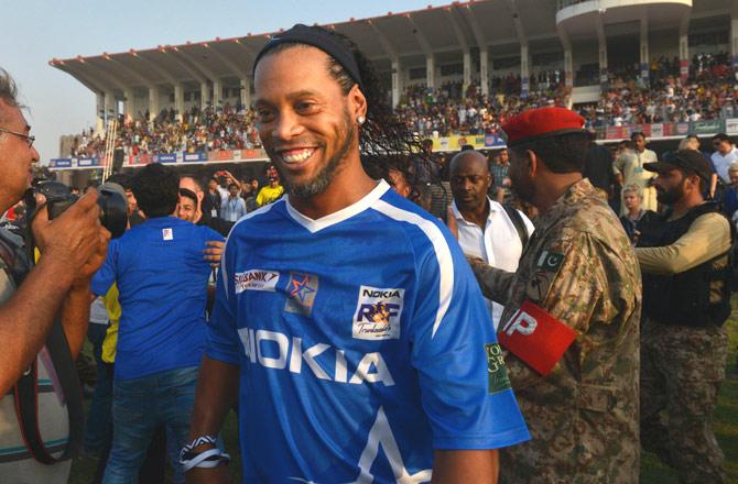Former player for FC Barcelona Brazilian Ronaldinho (C) arrives for friendly match with Pakistani football players on July 9, 2017 in Lahore. Eight of football