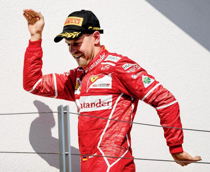 Ferrari driver Sebastian Vettel celebrates on the podium during the Hungary Grand Prix in Budapest yesterday. Pic/Getty Images