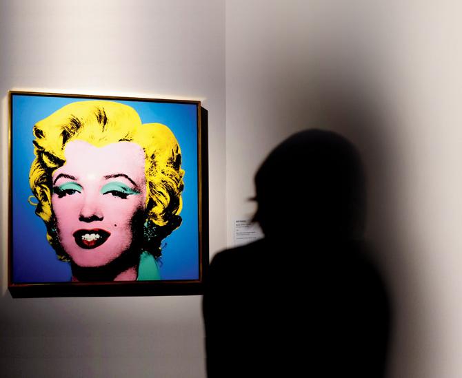 A woman sits in front of Blue Shot Marilyn as part of the exhibition, Warhol in the Museo della Fondazione Roma, Palazzo Cipolla. Pics/AFP