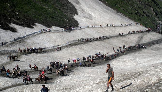 Pilgrims cross mountain trails during their religious journey to the Amarnath cave on the Baltal route, some 125 kms away from Srinagar on Saturday. 