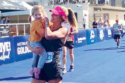 Warner's wife completes first marathon, gets a hug from daughter and husband