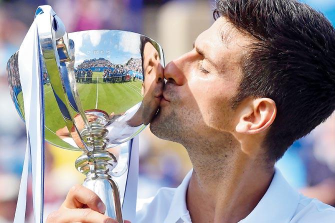 Novak Djokovic kisses his trophy after beating France’s Gael Monfils in Eastbourne on Saturday. Pics/AFP