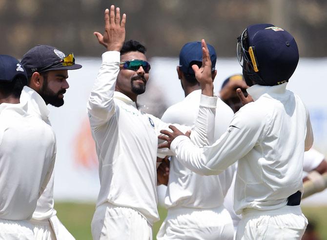 Ravindra Jadeja (C) celebrates with his teammates after he dismissed Sri Lankan cricket captain Rangana Herath