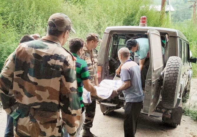 Medical workers shift the body of slain soldier Lance Naik Naseer to a morgue in Rajouri. Pic/AFP