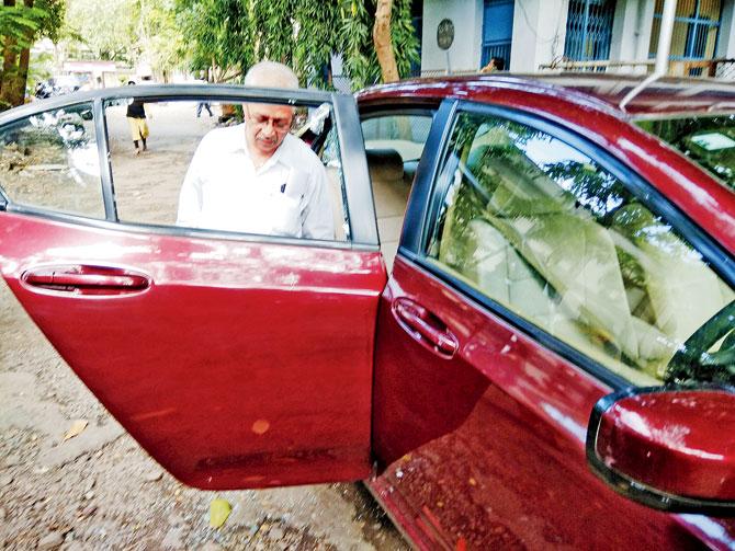 Special public prosecutor Manohar Kandalkar shows the damage to his car after the attack