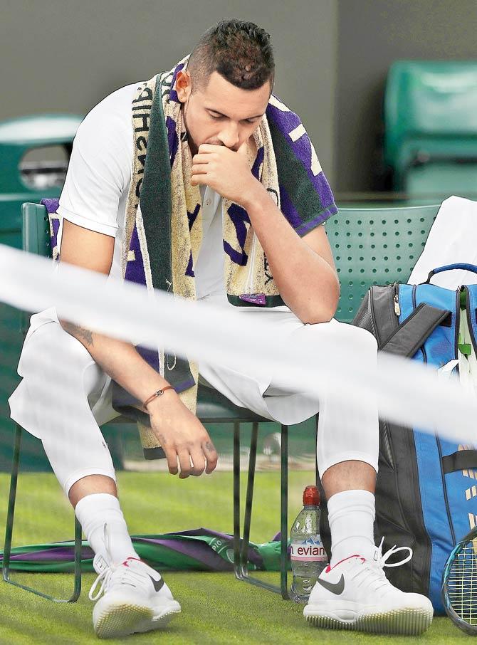 Nick Kyrgios reacts at the end of the second set against Pierre-Hughes Herbert at Wimbledon yesterday. Kyrgios retired from his first round match due to a hip injury