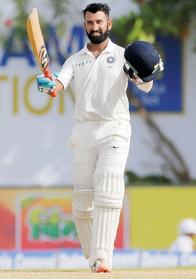 Cheteshwar Pujara celebrates his century during the first day’s play of the opening Test against SL in Galle yesterday. Pic/AP,PTI