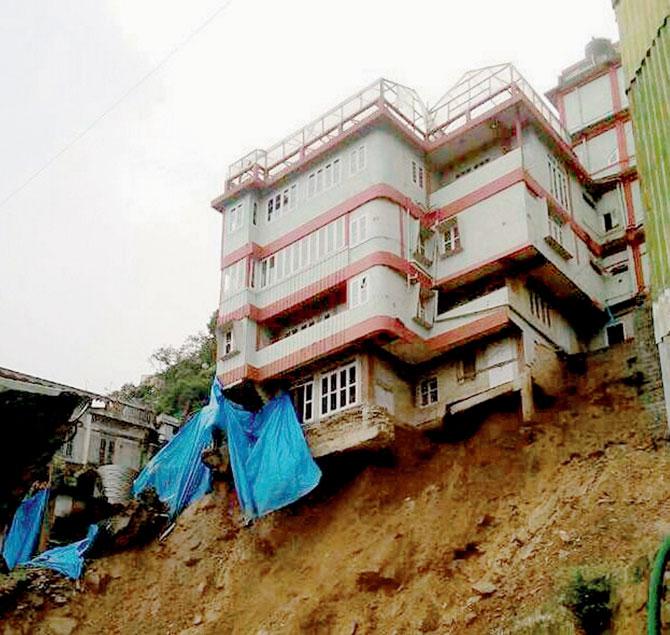 The earth under a multi-storied building caves in following heavy rains in Aizawl. PIC/PTI