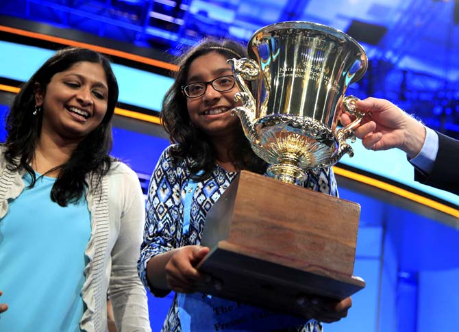 Ananya Vinay, 12, from Fresno, Calif., with her mother, holds her trophy after being declared the winner of the 90th Scripps National Spelling Bee. Pic/AFP