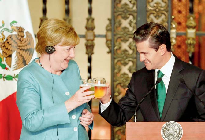 German Chancellor Angela Merkel and Mexico’s President Enrique Pena Nieto toast with beer after a joint press conference at the National Palace in Mexico City. Pic/AP