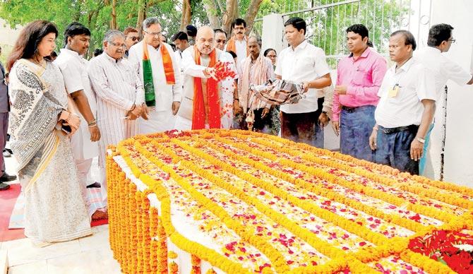 BJP chief Amit Shah showers flowers on freedom fighter Veer Narayan Singh’s memorial in Sonakhan, Chhattisgarh on Saturday, a day after he called Mahatma Gandhi a "chatur baniya". Pic/PTI