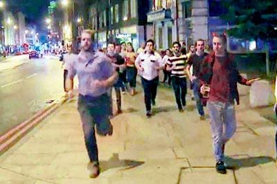Among the people running from the site of the attack was a man with a beer in hand. Pics/AFP