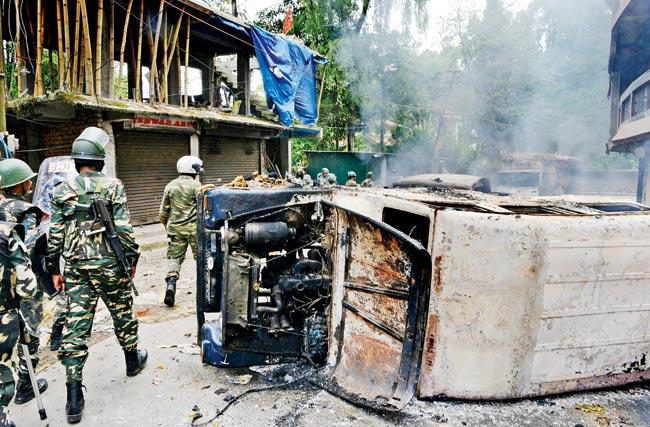Soldiers near vehicles torched by GJMâu00c2u0080u00c2u0088supporters in Darjeeling on Saturday. Pics/AFP