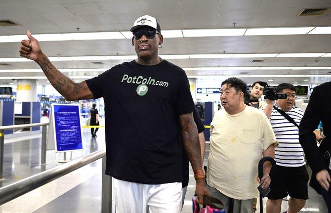 Former NBA basketball player Dennis Rodman of the US gestures as he arrives to check-in for his flight to North Korea at Beijing