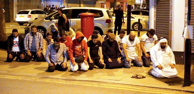 Muslims pray on a sidewalk in the Finsbury Park area of north London after the vehicle hit pedestrians. Pic/AFP