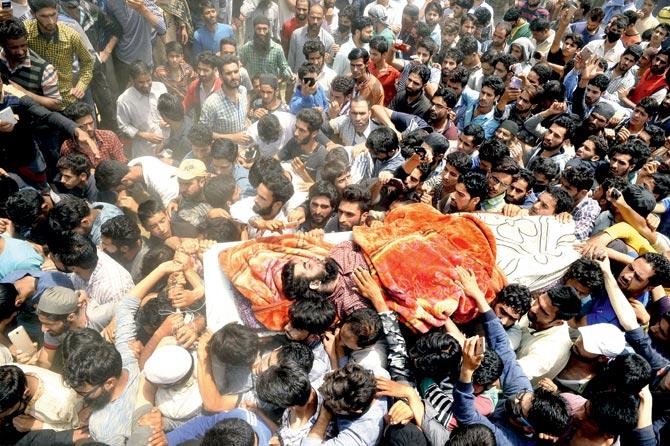 Villagers carry LeT leader Junaid Mattoo’s body during his funeral near Srinagar. Armed militants offered gun salute to Mattoo. Pic/AFP