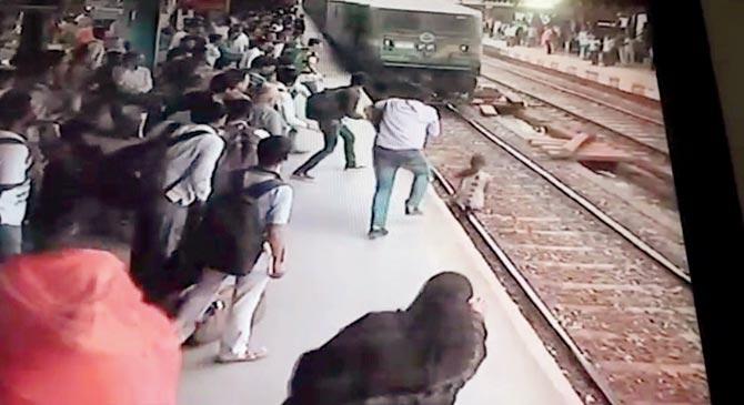She then runs towards the platform, with commuters ready to pull her to safety