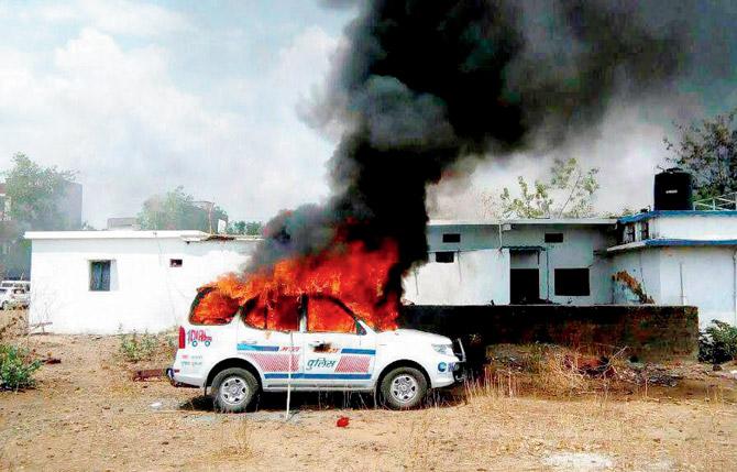 A police emergency vehicle set on fire by farmers. Pics/PTI