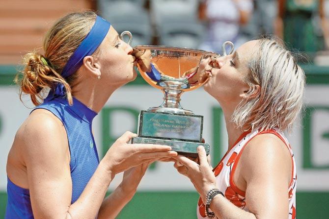 American Bethanie Mattek-Sands (left) and Czech Republic’s Lucie Safarova kiss the trophy after winning the French Open doubles final vs Australia’s Ashleigh Barty and Casey Dellacqua yesterday.Pic/PTI