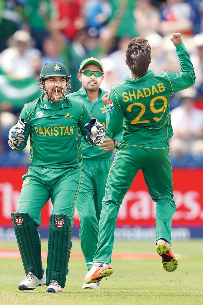 Pak’s Sarfraz Ahmed (left) is ecstatic after Shadab Khan bags an England wicket during the semis on Wednesday. Pic/Getty Images