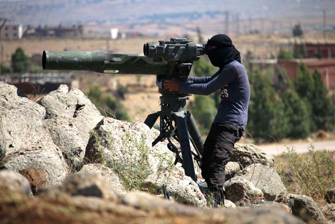 An opposition fighter looks for government forces