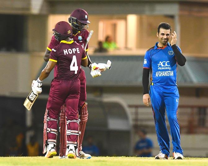 Dawlat Zadran (R) of Afghanistan watch as Shai Hope (L) and Jason Holder (C) of West Indies celebrate winning the 2nd ODI match between West Indies and Afghanistan. Pic/AFP