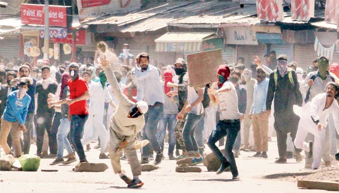 Youths throw stones on the police as they clashed yesterday in Srinagar. Pic/PTI