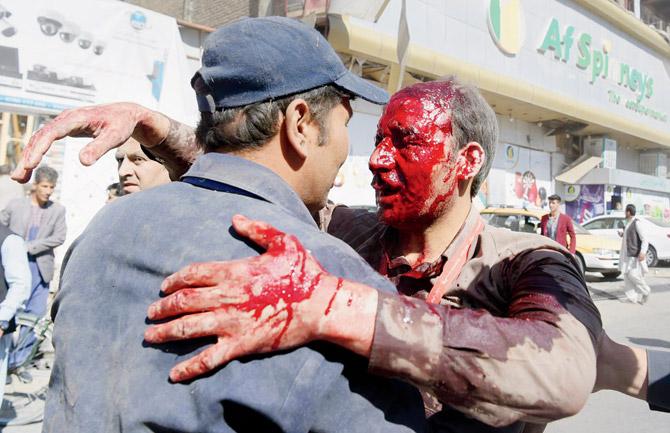 A wounded Afghan man receives assistance at the site of the attack in Kabul. Pic/AFP