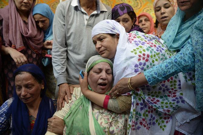 Relatives of police officer Mohammad Ayub Pandith mourn at his home in Srinagar