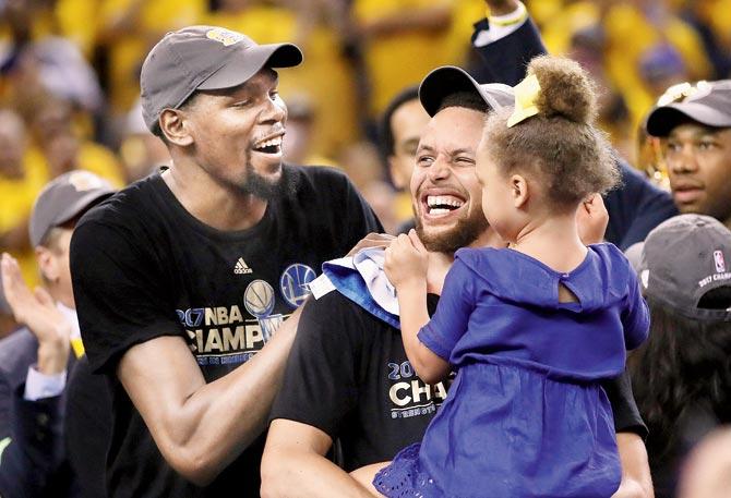 Golden State Warriors’ Kevin Durant (left) celebrates with teammate Stephen Curry after GSW’s 129-120 win over Cleveland Cavaliers in Game 5 of the NBA Finals at the ORACLE Arena on Monday. Pic/AFP