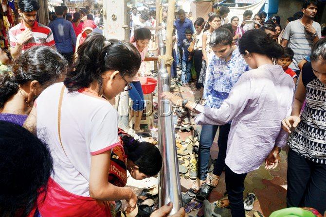 Residents of buildings inside the Mahalaxmi temple compound are fed up with the huge pile of footwear littering their building entrances. Pic/Bipin Kokate