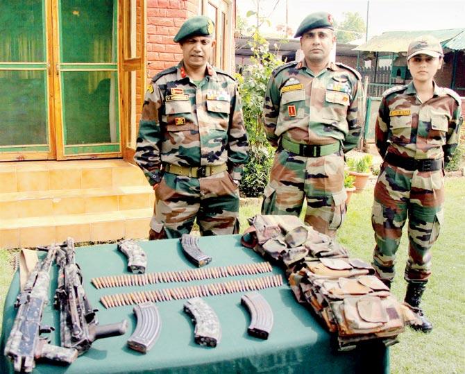 Army personnel display arms and ammunition recovered from the  two Hizbul Mujahideen terrorists. Pic/PTI