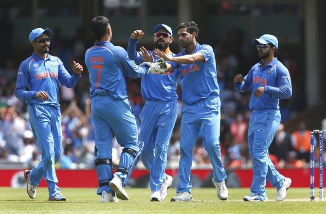 India’s Bhuvneshwar Kumar (R) celebrates taking the wicket of South Africa’s Kagiso Rabada for 5 runs during the ICC Champions Trophy match between South Africa. Pic/AFP
