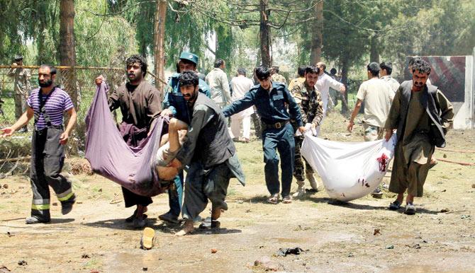 Afghans carry the bodies of men at after the bombing. Pic/AFP