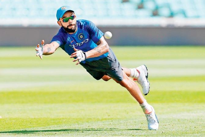 India skipper Virat Kohli dives to take a catch during a practice session on the eve of the Champions Trophy final against Pakistan at The Oval on Saturday. Pic/AFP
