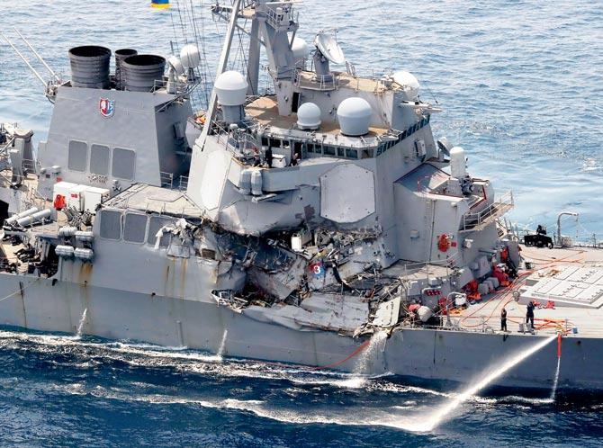 The damaged guided missile destroyer USS Fitzgerald; (right)âu00c2u0080u00c2u0088the container that collided with the US Navy ship. Pics/AFP/AP