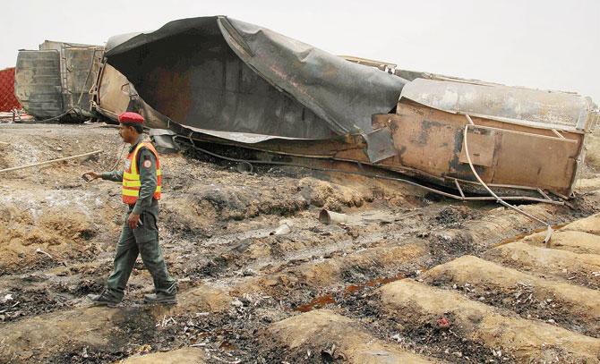 Pakistani rescue workers gather beside the oil tanker which caught fire. Pic/AFP