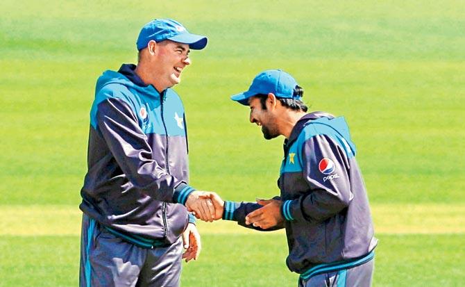 Pakistan coach Mickey Arthur (left) and captain Sarfraz Ahmed share a light moment during a training session in Cardiff yesterday.