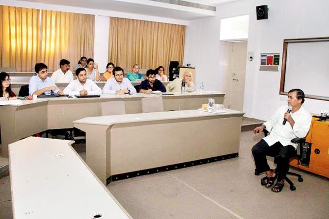 Sunder Pujari, owner of a pan shop in Andheri, talks to management students of SP Jain Institute of Management and Research, during an interactive session